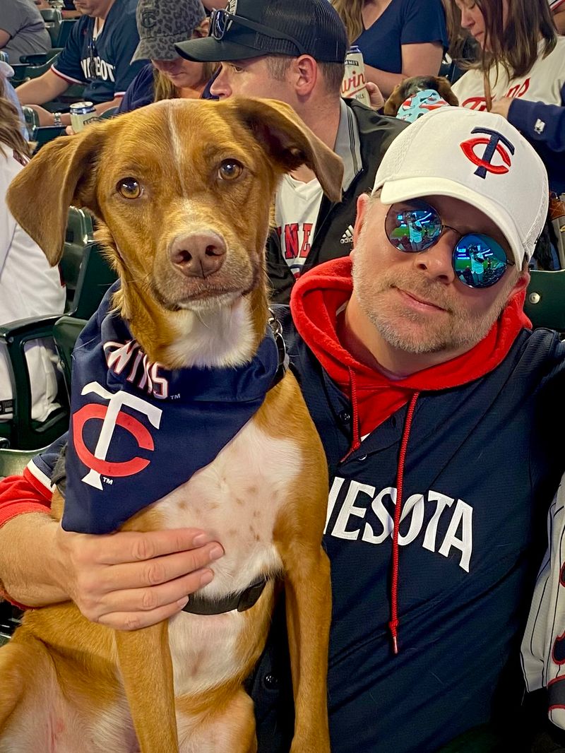 Chad Juettner and his dog Otis, in a Twins bandana, at a ballgame